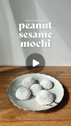 a white plate topped with powdered sugar covered cookies on top of a wooden table