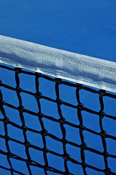 a tennis net with a blue sky in the backgroung area behind it