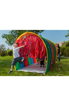 a person jumping in the air near a colorful structure