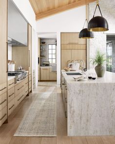 a kitchen with wooden cabinets and white marble counter tops, along with an area rug on the floor