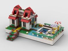 a lego model of a house with a pool and beach umbrellas on the roof