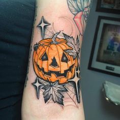 a tattoo with a pumpkin and leaves on it