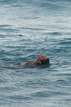 a man swimming in the ocean with his eyes closed