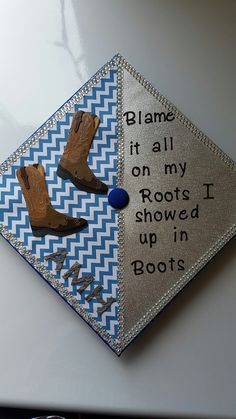 a graduation cap with boots on it that says, flame it all on my roots i showed up in boots