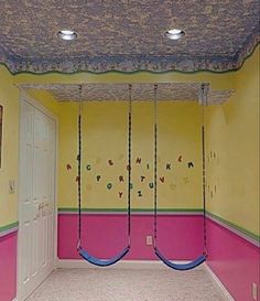 an empty room with two swings hanging from the ceiling