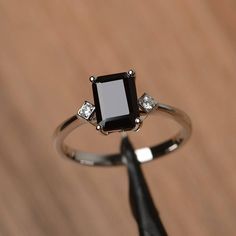 a black diamond ring sitting on top of a wooden table