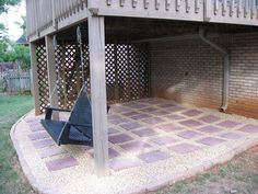 an outdoor patio with a swing set and brick pavers