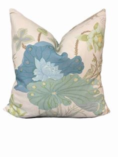 a white pillow with blue and green flowers on it