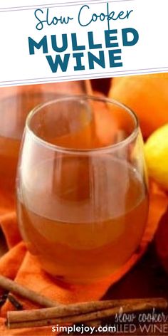 two glasses filled with mulled wine sitting on top of a table next to oranges and cinnamon sticks