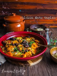 a red bowl filled with lots of food on top of a wooden table next to other dishes