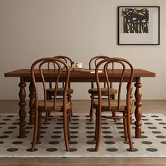 a dining room table and chairs with polka dot rug on the floor in front of it