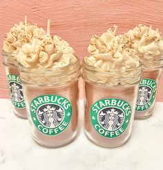 four starbucks coffee cups with whipped cream in them