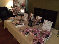 the table is set up with books and gifts for someone's special occasion,