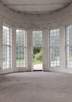 an empty room with three windows and a door