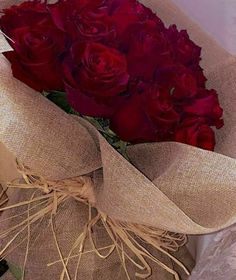 a bouquet of red roses wrapped in burlock