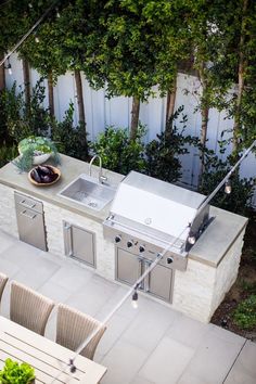 an outdoor kitchen with grill and sink