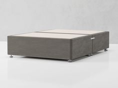 a grey ottoman sitting on top of a white table