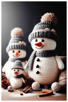 two crocheted snowmen with hats and scarfs are standing next to balls of yarn