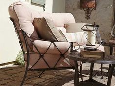 a chair and table sitting on a patio with brick pavers flooring next to it