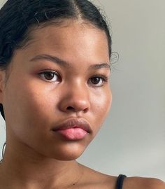 a close up of a person with a necklace on her neck and an earring