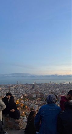 people sitting on top of a building overlooking the city