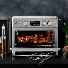 an oven with food cooking in it on a counter next to other kitchen items and utensils