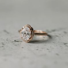 a close up of a ring with a diamond in the center on a gray surface