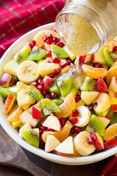 fruit salad with dressing being poured into it