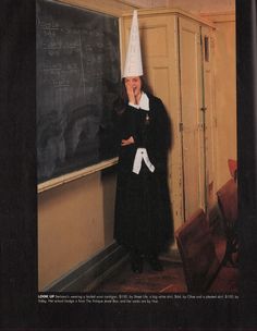 an old woman wearing a party hat in front of a chalkboard with writing on it