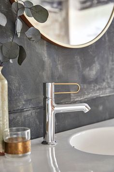 a bathroom sink with a metal faucet and soap dispenser next to it