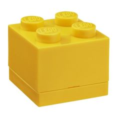 a yellow lego block with four small round knobs