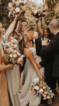 a group of people standing around each other holding flowers