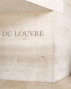 the words du louvre are carved into the wall