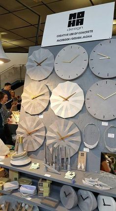 a group of people standing around a table with clocks on it