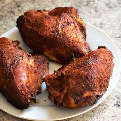 four pieces of cooked chicken on a white plate