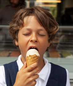 a young boy eating an ice cream cone