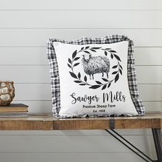 a black and white pillow sitting on top of a wooden table