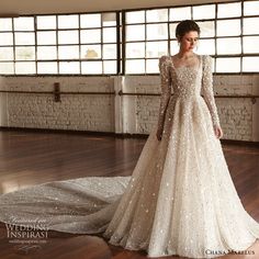 a woman in a long sleeved wedding dress with sequins on the skirt