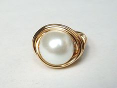 Pearl Ring Large White Swarovski Glass pearl wrapped in 14k gold filled wire. This is a large glass bead approximately 10-12mm. Beautiful large white pearl surrounded in gold. 14K Gold Pearl ring makes a wonderful Mothers Day Gift! Ring sizes available 3-16. Ring can be custom sized 1/2 or 1/4 sizes. Please provide correct sizing in drop down box in shop listing. Once made this ring type can not be re-sized. SIGN UP FOR OUR EMAIL LIST FOR 10% OFF Copy and past URL in your browser http://eepurl.c Wire Wrapped Pearl Wedding Ring, Elegant White Wire Wrapped Pearl Ring, White Wire Wrapped Pearl Ring For Wedding, Gold Pearl Ring, Gold Filled Ring, Jewelry Silver, Types Of Rings, Gold Pearl, Ring Gold