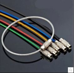 four different colored wires connected to each other on a black surface with one wire in the middle