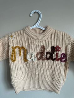 a knitted sweater with the word mom written on it