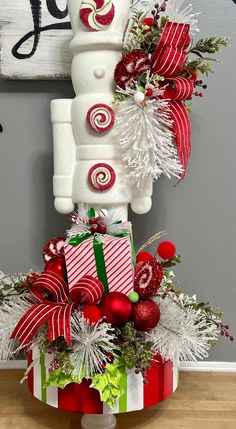 a white snowman sitting on top of a box filled with christmas decorations and presents