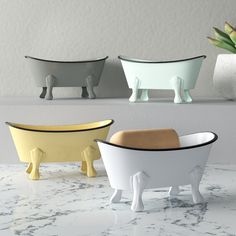 three ceramic bath tubs sitting on top of a counter next to a succulent plant