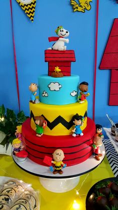 there is a multi layer cake decorated with cartoon characters on the top and bottom tier