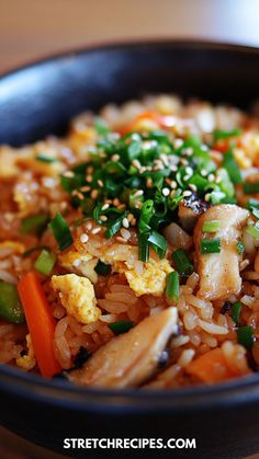 a black bowl filled with rice and vegetables