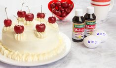 the cake is decorated with cherries and white icing, along with other ingredients