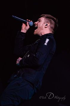 a man with ear buds on his ears singing into a microphone