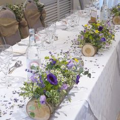 the table is set with flowers and wine glasses