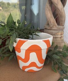 an orange and white planter sitting on top of a table