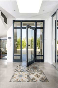 an open door leading to another room with glass doors and tile flooring on the ground